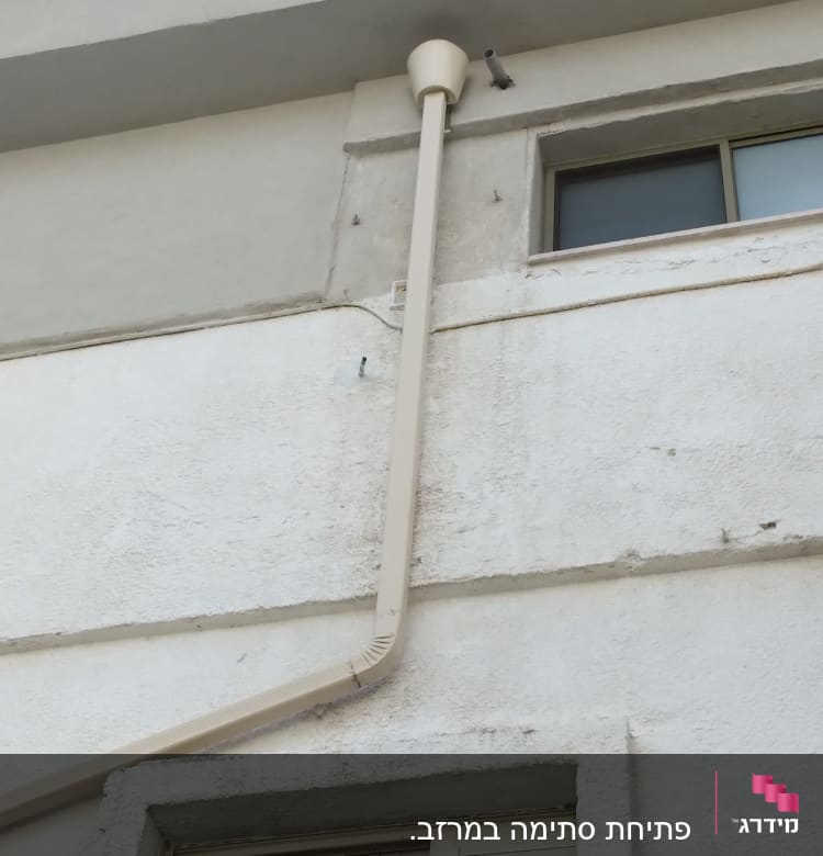 צינור ניקוז חיצוני מחובר לקיר בניין